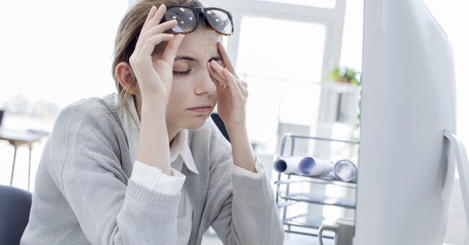 Eine junge Frau reibt sich müde ihre überanstrengten Augen.