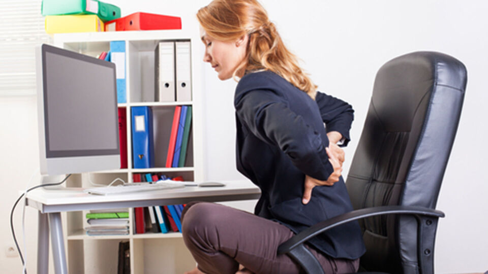 Frau_Rückenschmerzen_Büro - Lange Schreibtischarbeit schadet unserem Rücken. - © Shutterstock