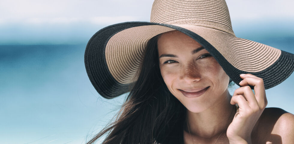 Sonnenschutz Frau mit Hut am Strand