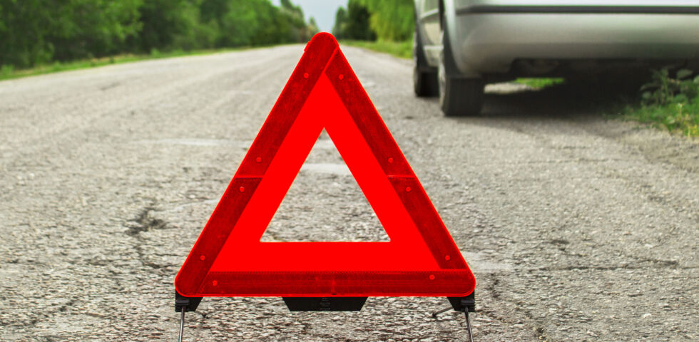 Erste Hilfe_Warndreieck bei einem Auto - Sichern Sie Unfallstellen immer ab. Bei Verkehrsunfällen sollte man zum Beispiel in ausreichender Entfernung ein Warndreieck aufstellen. So kann der nachfolgende Verkehr rechtzeitig auf die Gefahrenzone reagieren.
