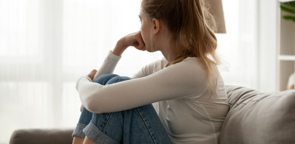 Eine traurige Frau sieht aus dem Fenster - Depressionen können jeden treffen.